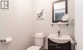 Clarington (Courtice) apartment for rent - A white toilet sits next to a sink in a small bathroom.