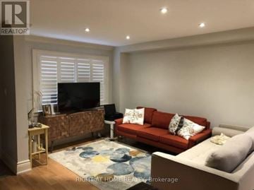 Toronto (Briar Hill-Belgravia) apartment for rent - A living room with a red couch and a television.
