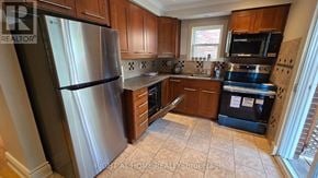 Toronto (Briar Hill-Belgravia) apartment for rent - A kitchen with a stainless steel refrigerator and wooden cabinets.