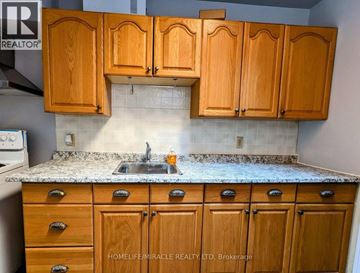 Halton Hills (Georgetown) apartment for rent - A kitchen with wooden cabinets and a granite countertop.