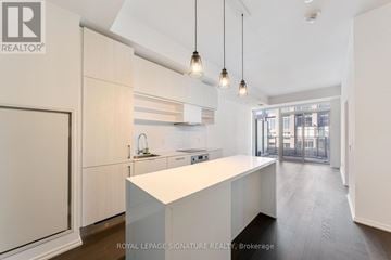 Toronto (Mount Pleasant West) condo for rent - A modern kitchen with white cabinets and a central island.