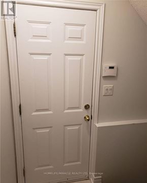 Brampton (Snelgrove) apartment for rent - A white door with a gold handle and a light switch on the wall.