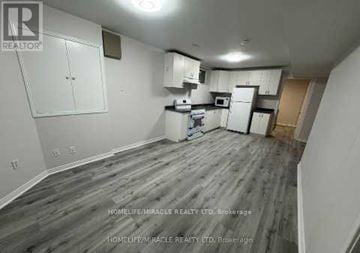 Brampton (Snelgrove) apartment for rent - A kitchen area with white cabinets and a microwave above the stove.