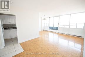 Toronto (Playter Estates-Danforth) condo for rent - A spacious room with wooden flooring and white walls.