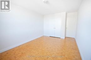 Toronto (Playter Estates-Danforth) condo for rent - A room with wooden flooring and white walls, with two doors.