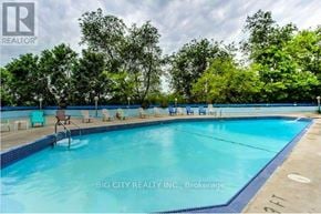 Toronto (Playter Estates-Danforth) condo for rent - A swimming pool with lounge chairs and trees in the background.