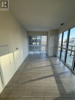 Toronto (Mimico) condo for rent - A long hallway with a view of a city skyline through the windows.