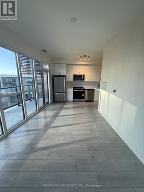 Toronto (Mimico) condo for rent - A spacious room with a kitchen area and large windows.