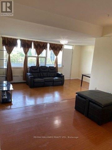 Toronto (Henry Farm) condo for rent - A living room with a black sofa and a wooden floor.