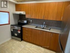 Toronto (Henry Farm) condo for rent - A kitchen with wooden cabinets and a black oven.
