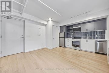 Hamilton (Corktown) multi-family for rent - A kitchen with white cabinets and stainless steel appliances.