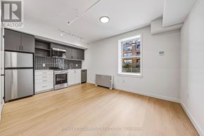 Hamilton (Corktown) multi-family for rent - A spacious kitchen with wooden floors and stainless steel appliances.