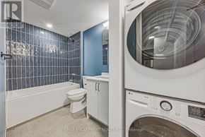 Hamilton (Corktown) multi-family for rent - A washing machine is in the foreground of a bathroom with blue tiles.