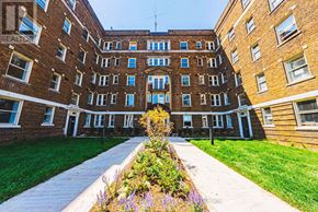 Hamilton (Corktown) multi-family for rent - A view of a courtyard with a walkway and a building with a balcony.