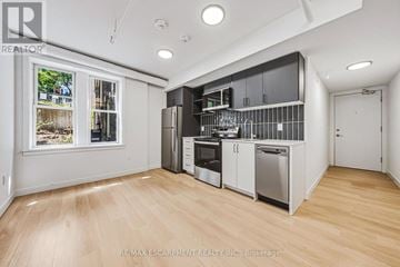Hamilton (Corktown) multi-family for rent - A kitchen with white cabinets and stainless steel appliances.
