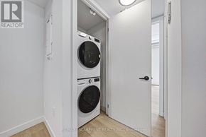 Hamilton (Corktown) multi-family for rent - A white laundry room with a washer and dryer built into the wall.