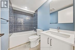 Hamilton (Corktown) multi-family for rent - A white toilet sits next to a white sink in a blue bathroom.