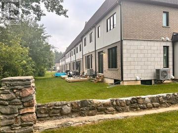 Cambridge townhouse for rent - A building with a stone wall in front of it.