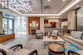 Oakville (Br Bronte) condo for rent - A modern living room with a large sofa, armchairs, and a coffee table.