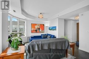 Oakville (Br Bronte) condo for rent - A living room with a grey sofa and a painting on the wall.
