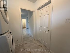 Toronto (Yorkdale-Glen Park) apartment for rent - A hallway with a white door and a washing machine.