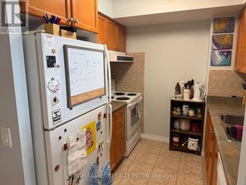 Toronto (West Humber-Clairville) condo for rent - A white fridge with a calendar magnet on it in a kitchen.