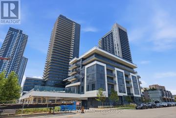 Mississauga (Hurontario) condo for rent - A modern multi-story building with a glass facade is the focal point of the image.