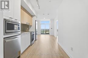 Mississauga (Hurontario) condo for rent - A modern kitchen with stainless steel appliances and wooden cabinets.