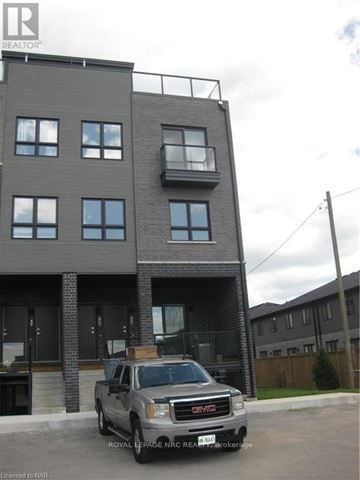 Niagara Falls (Morrison) townhouse for rent - A grey GMC truck is parked in front of a modern building.