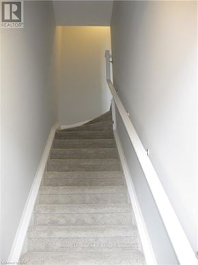 Niagara Falls (Morrison) townhouse for rent - A staircase with a carpeted runner and white walls.