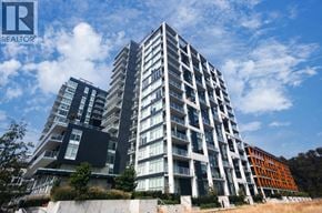 Vancouver apartment for rent - A modern multi-story residential building with balconies and a clear blue sky above.