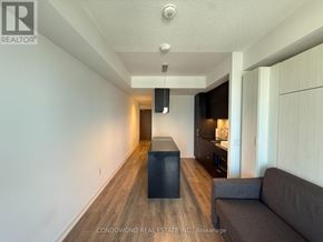 Toronto (Waterfront Communities) condo for rent - A living room with a grey couch and a black box on the floor.
