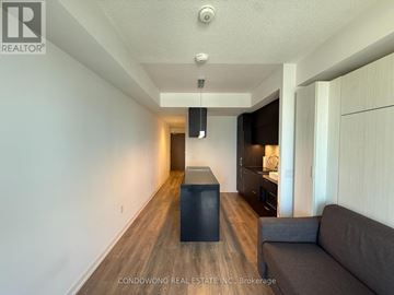 Toronto (Waterfront Communities) condo for rent - A living room with a grey couch and a black box on the floor.