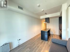 Toronto (Waterfront Communities) condo for rent - A living room with a grey couch and a black cabinet.
