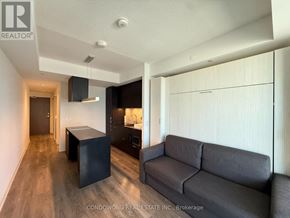 Toronto (Waterfront Communities) condo for rent - A living room with a grey couch and a black box-like object.