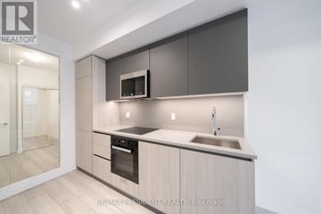 Toronto (Waterfront Communities) condo for rent - A modern kitchen with a sink and a microwave.