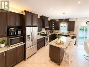 Oakville (Jc Joshua Creek) apartment for rent - A kitchen with dark brown cabinets and stainless steel appliances.