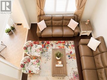 Oakville (Jc Joshua Creek) apartment for rent - A living room with a brown couch and a floral rug.