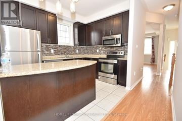 Clarington (Bowmanville) apartment for rent - A kitchen with dark brown cabinets and a stone backsplash.
