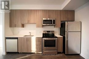 Burlington (Tansley) house for rent - A kitchen with wooden cabinets and stainless steel appliances.