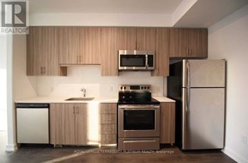 Burlington (Tansley) house for rent - A kitchen with wooden cabinets and stainless steel appliances.