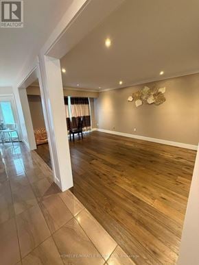 Burlington (Headon) apartment for rent - A spacious room with wooden flooring and a wall decoration.