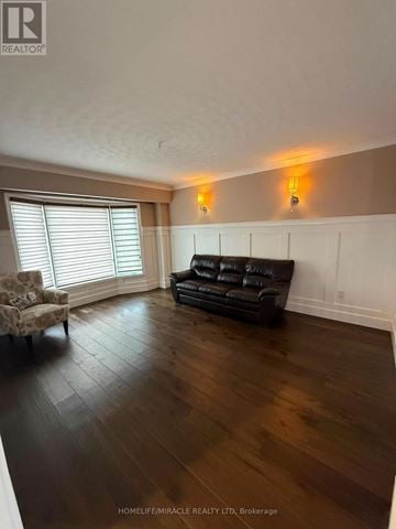 Burlington (Headon) apartment for rent - A living room with a black couch and a chair with a patterned cushion.