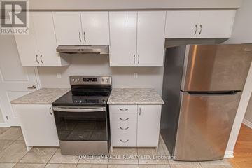 Barrie (Innis-Shore) apartment for rent - A kitchen with white cabinets and a stainless steel refrigerator.