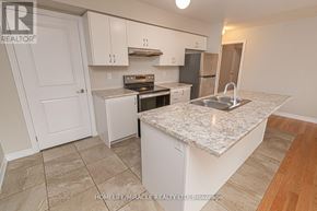Barrie (Innis-Shore) apartment for rent - A kitchen with a marble countertop and white cabinets.