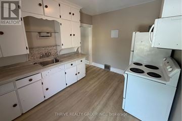 London East (East F) apartment for rent - A kitchen with white cabinets and a white stove top oven.