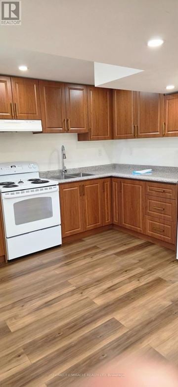 Toronto (Wexford-Maryvale) apartment for rent - A kitchen with wooden cabinets and a white stove top oven.