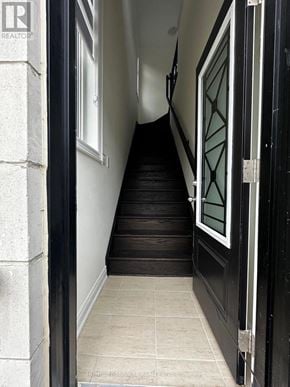 Bradford West Gwillimbury (Bond Head) apartment for rent - A staircase with a black door on the right.
