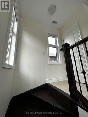 Bradford West Gwillimbury (Bond Head) apartment for rent - A staircase in a house with a window and a door in the background.