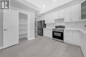 Fort Erie (Ridgeway) apartment for rent - A modern kitchen with white cabinets and a black fridge.